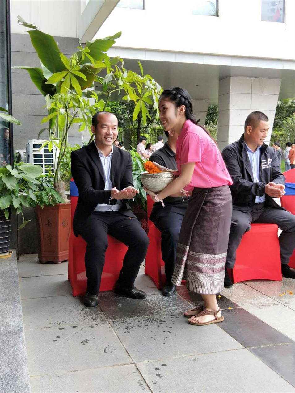 老撾駐廣西留學(xué)生代表將浸有花瓣的香水灑客人的手上，表示對嘉賓的美好祝福（圖一）